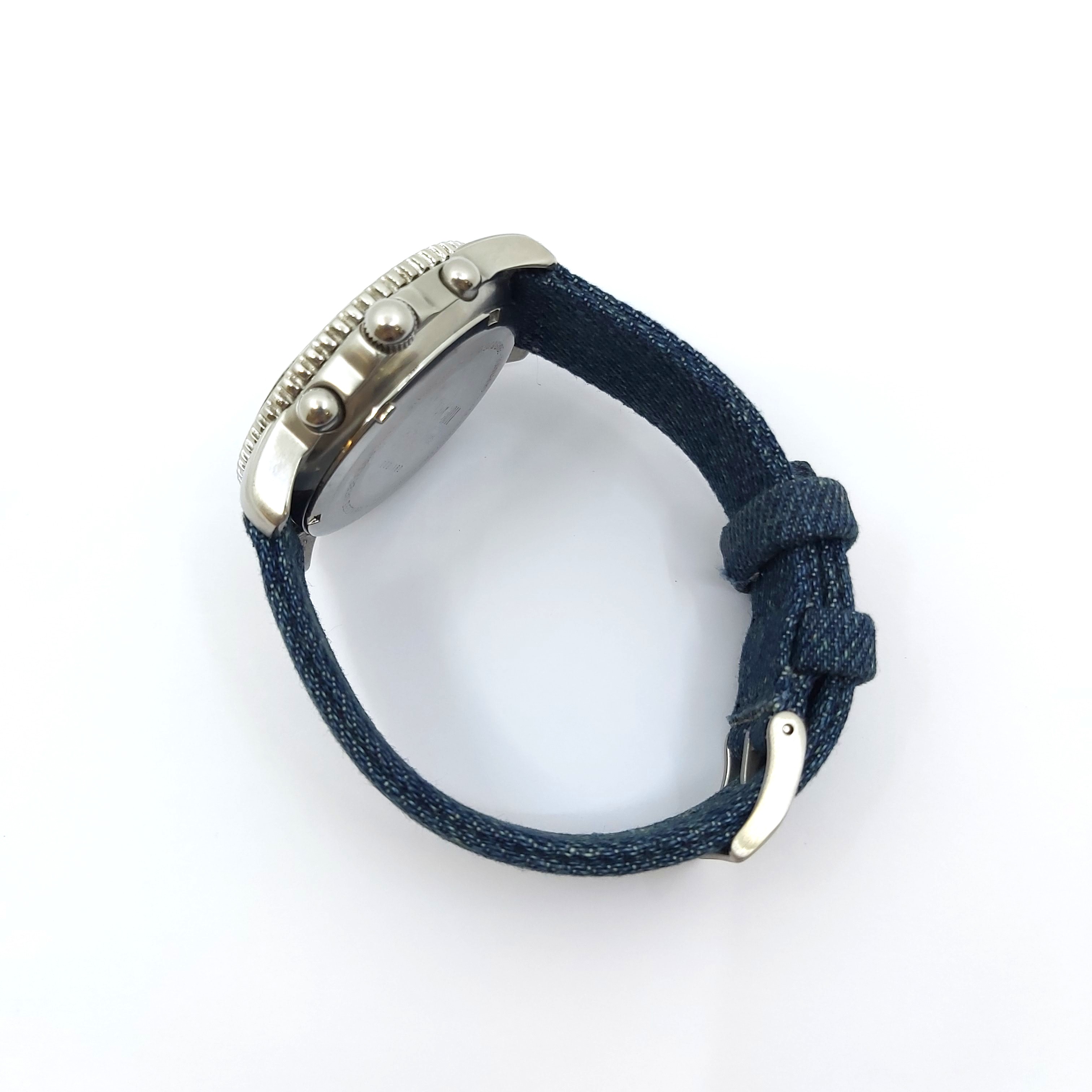Seitliche Ansicht TNG Tornado Watch Sammleruhr 1999 mit blauem Textilband, Edelstahlgehäuse, sichtbaren Drückern, Faltschließe und altergemäßen Tragespuren, Quarzuhrwerk, Originalbox und Garantie im Lieferumfang.