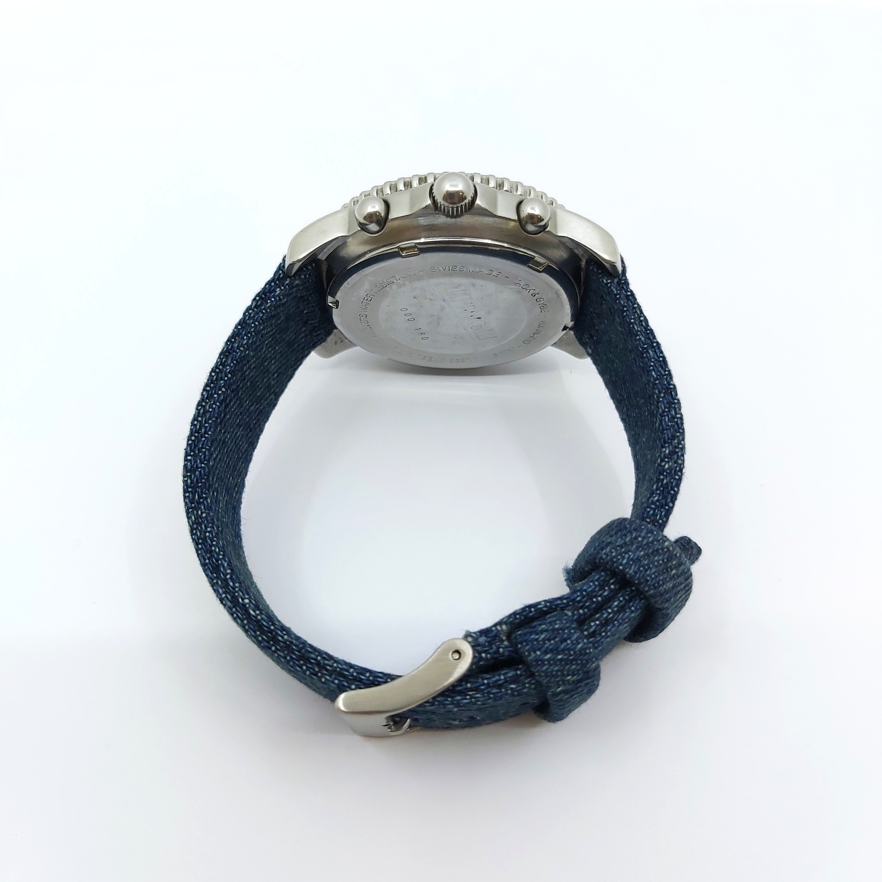 Rückansicht der TNG Tornado Watch Sammleruhr von 1999 aus Edelstahl mit blauem Textilarmband und Faltschließe, sichtbare Tragespuren am Gehäuse, Quarzuhrwerk, geprüfte Funktion, Vintage Chronograph.