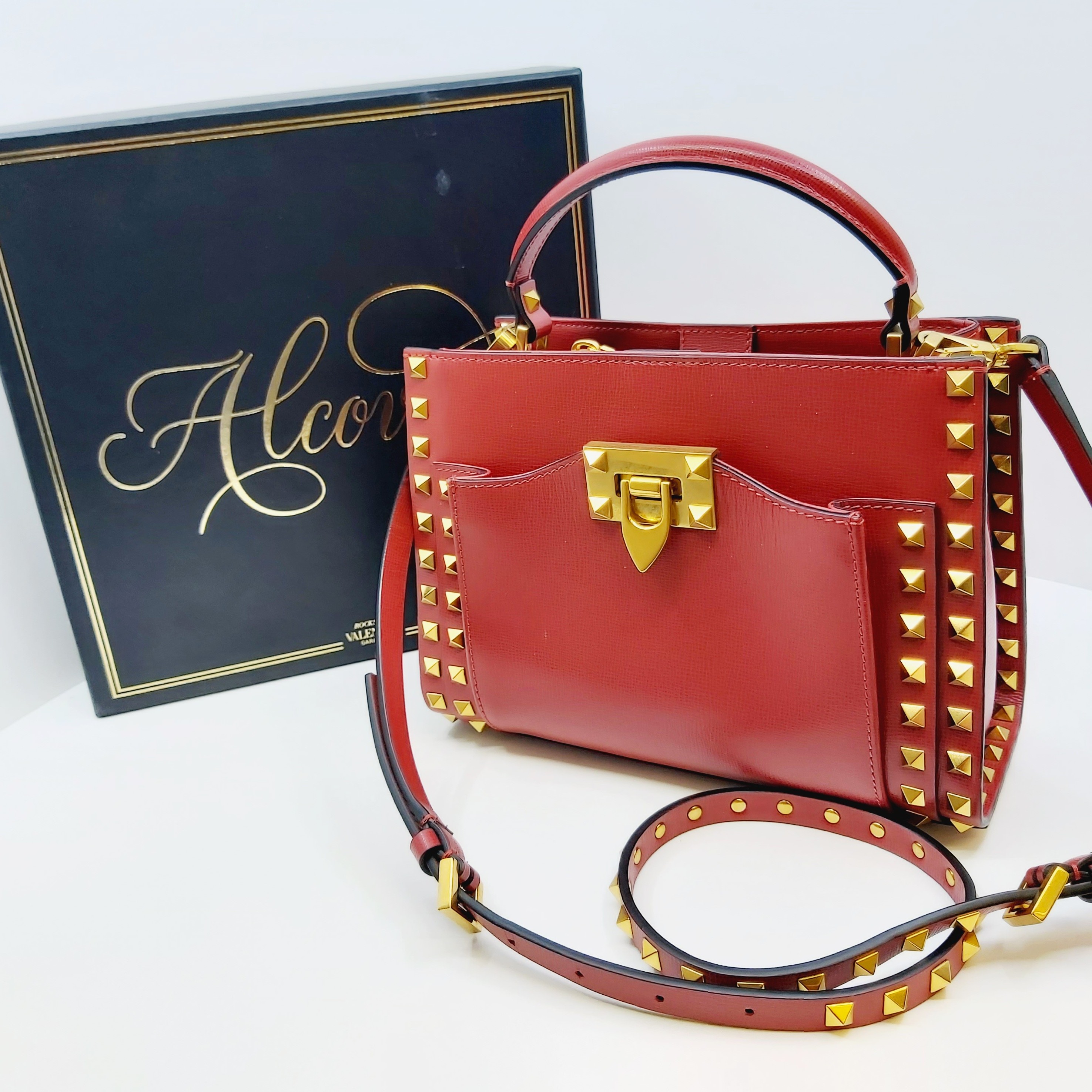 Rote Valentino Rockstud Alcove Handtasche aus Leder, kleines Modell mit goldenen Nieten, Top-Handle, verstellbarem Crossbody-Riemen, Box, Staubbeutel und Ersatznieten, Größe ca. 22x16x9 cm, luxuriöses Design.
