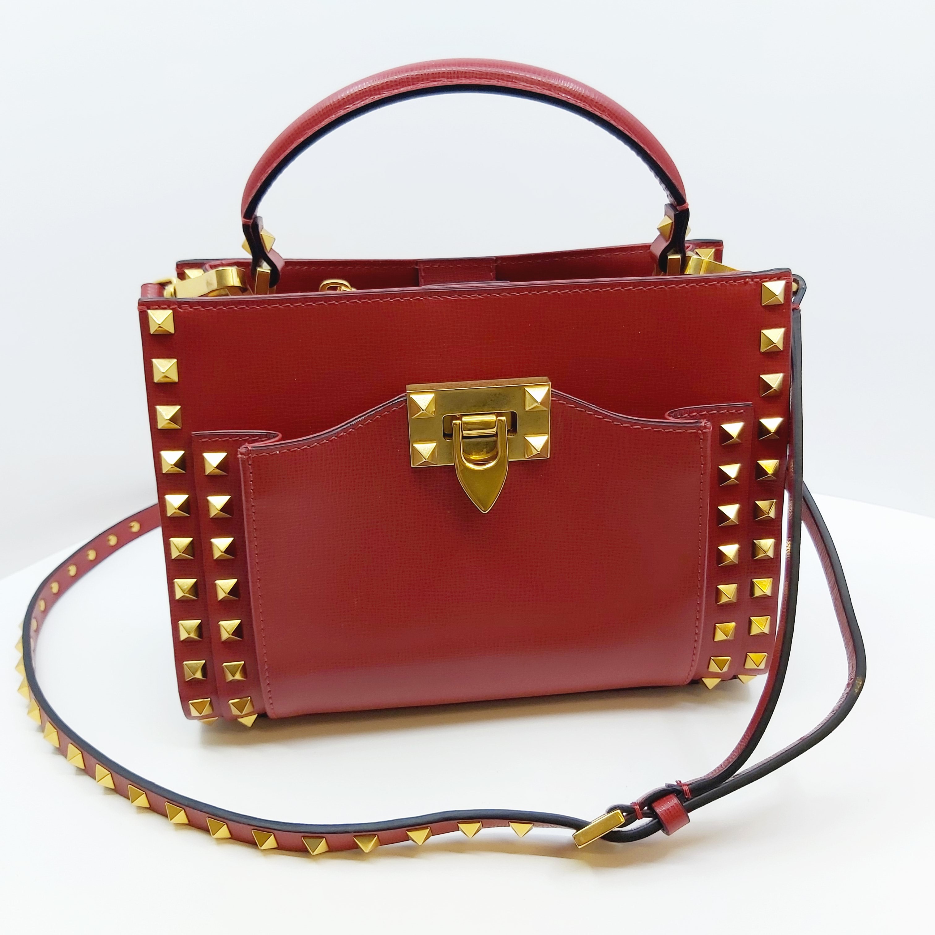 Rote Valentino Rockstud Alcove Handtasche, kleine Leder Top-Handle Bag mit goldenen Nieten, Fronttasche, goldener Verschluss, verstellbarer Crossbody-Riemen, 22x16x9 cm, inkl. Box, Staubbeutel, Ersatznieten.