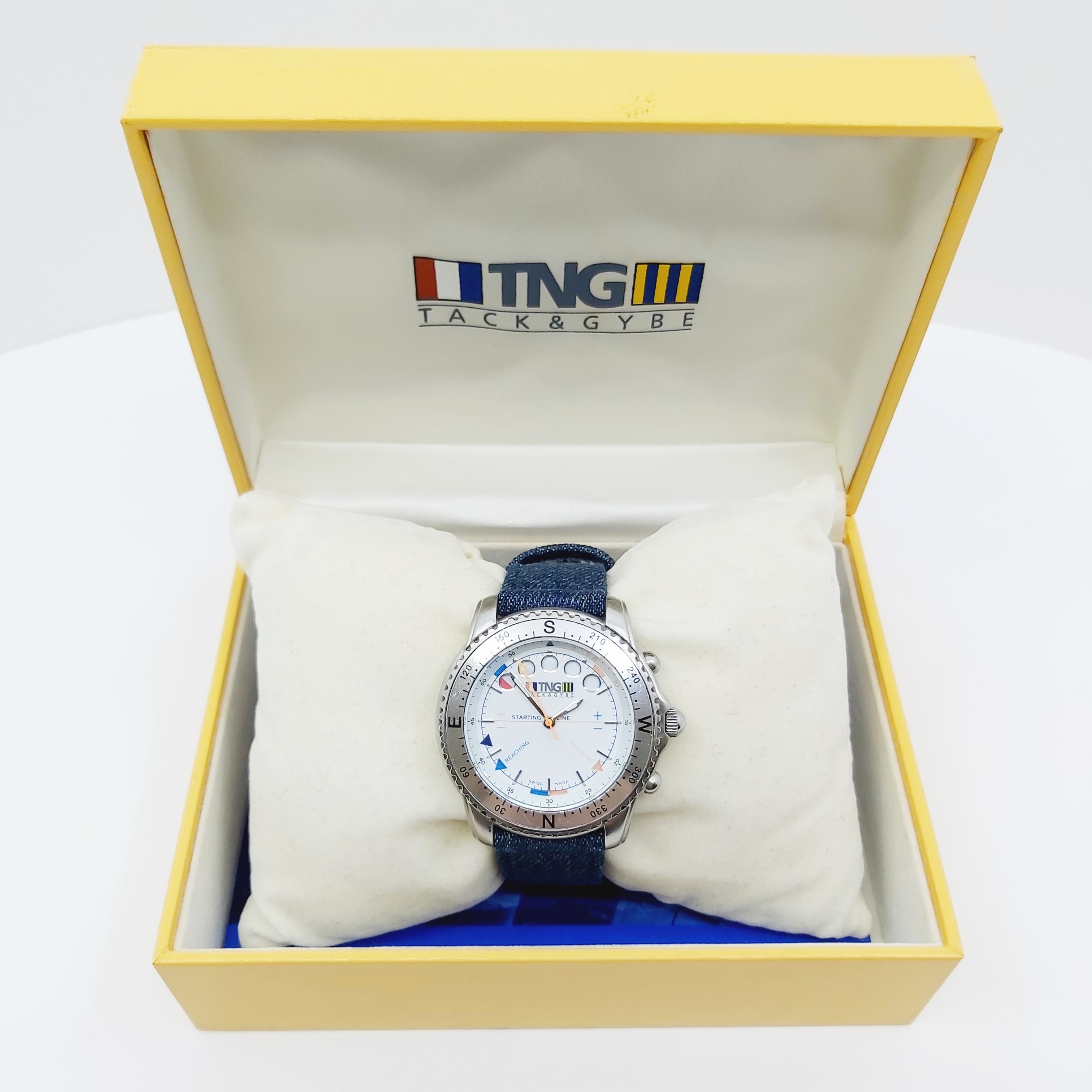 TNG Tornado Watch Armbanduhr, Edelstahl, 42,2 mm, weißes Zifferblatt, Textilband, Sammlerstück von 1999 mit Tragespuren, in Originalbox, Zubehör inklusive, klares Design, für Segler und Uhrenliebhaber.
