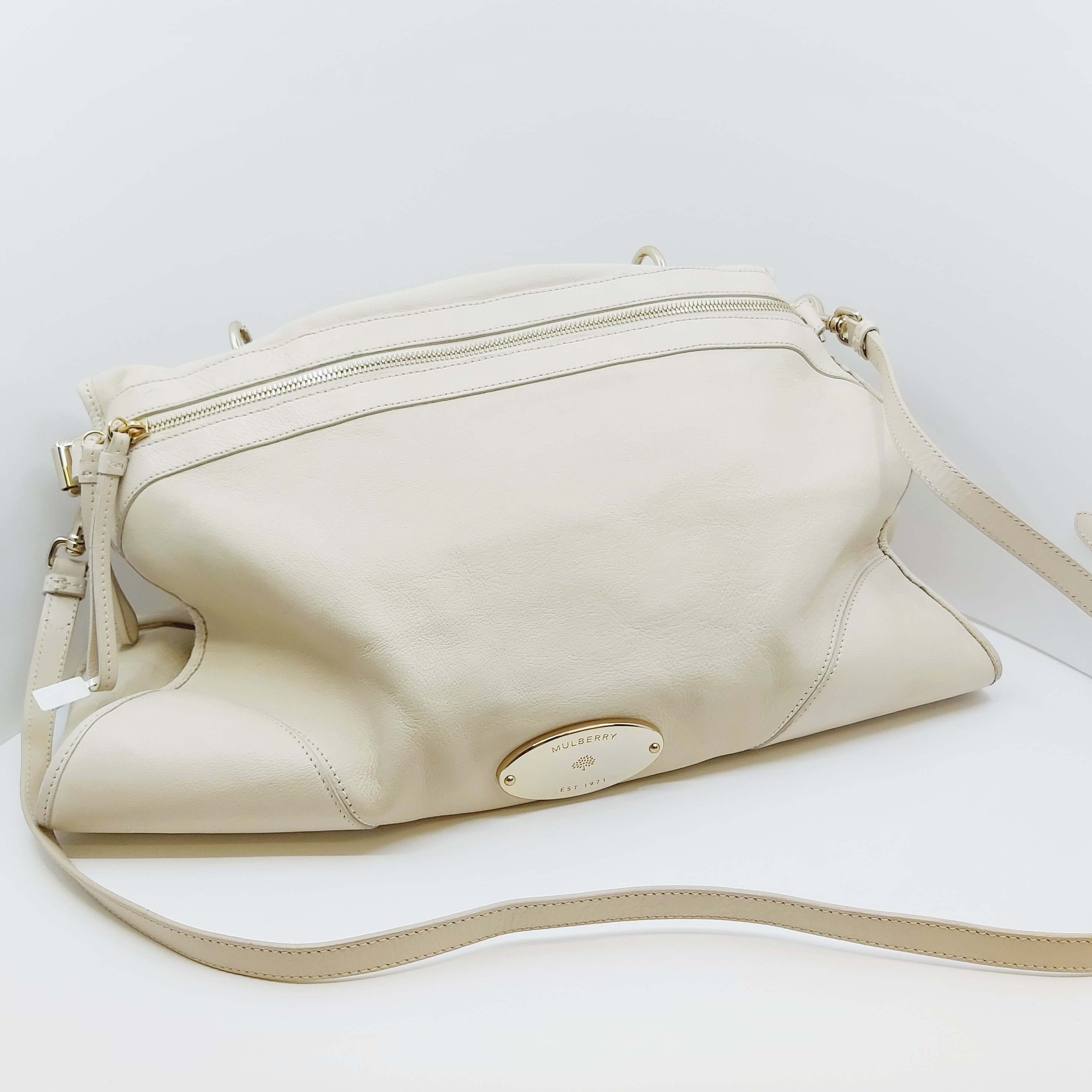 Cremefarbene Mulberry Taylor Ledertasche mit goldfarbenen Details, abnehmbarem Schulterriemen (max. 126cm), Maße 43x28x15cm, sichtbare Gebrauchsspuren, inklusive Rechnung, liegend auf hellem Hintergrund.