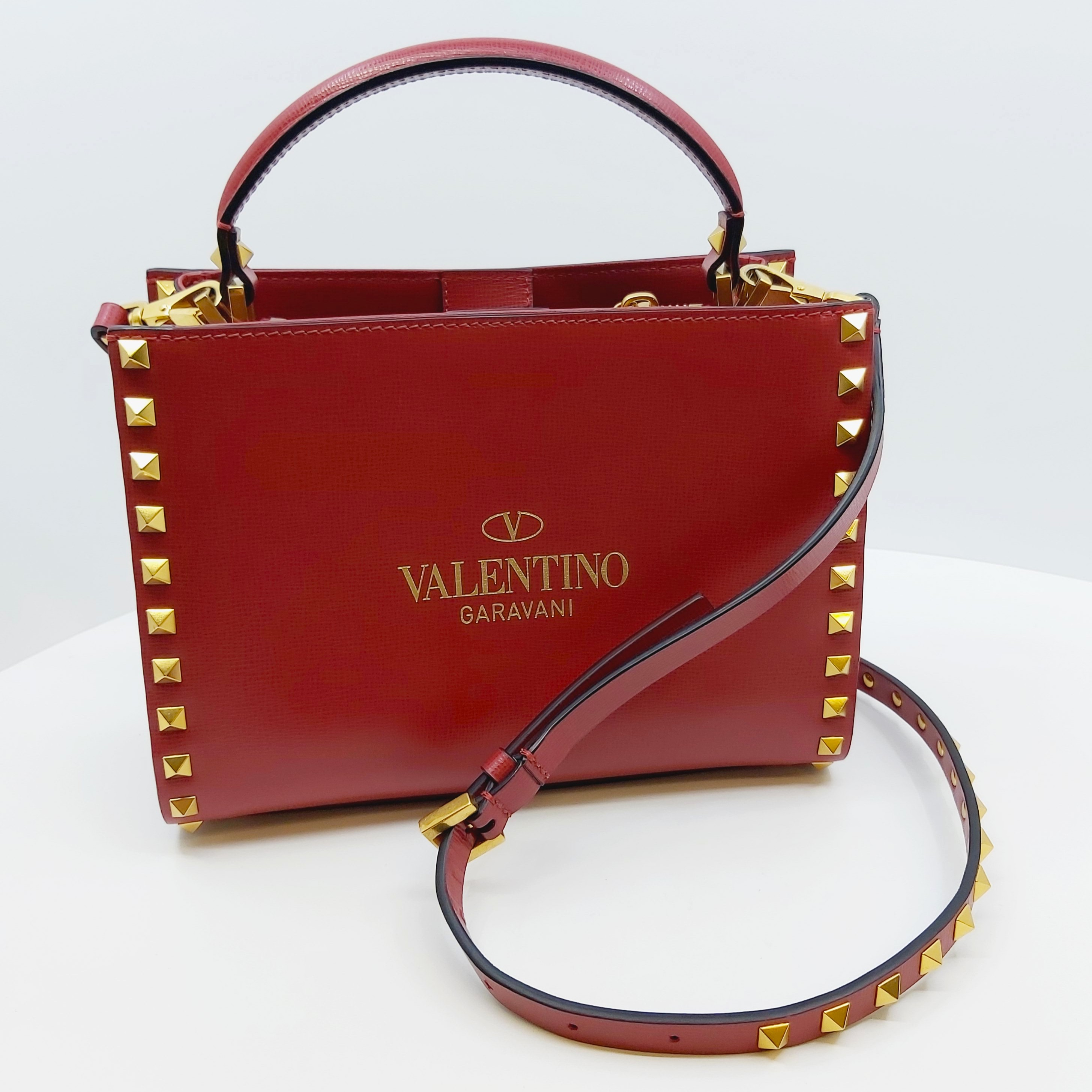 Rote Valentino Rockstud Alcove Handtasche aus Leder, kleine Top-Handle Bag mit goldenen Nieten, verstellbarem Crossbody-Riemen, ca. 22x16x9cm, inklusive Box, Staubbeutel und Ersatznieten, luxuriöses Designer-Accessoire.